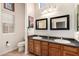 Bathroom featuring double sinks and a vanity with dark granite countertops at 7722 W Libby St, Glendale, AZ 85308