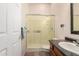 This bathroom features a granite countertop, a dark vanity and an enclosed tiled shower with sliding glass doors at 7722 W Libby St, Glendale, AZ 85308