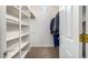 A walk-in closet with carpeted floors and built-in shelves and rods at 7722 W Libby St, Glendale, AZ 85308