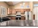 Kitchen features wood cabinets, granite counters, and modern appliances at 7722 W Libby St, Glendale, AZ 85308
