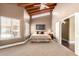 Spacious main bedroom featuring vaulted ceilings with wood beams, carpet floors and natural light from a large window at 7722 W Libby St, Glendale, AZ 85308