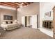 This carpeted main bedroom offers a brick fireplace, ceiling fan and double doors that lead into the main bathroom at 7722 W Libby St, Glendale, AZ 85308