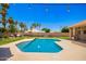 Inviting pool with waterfall feature surrounded by lush landscaping and mature trees at 7722 W Libby St, Glendale, AZ 85308