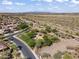 Aerial view of a residential area with a playground, desert vegetation, and mountains on the horizon at 10749 W Lariat Ln, Peoria, AZ 85383