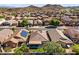 A desert community with tiled-roofed homes, lush backyards, covered patios, solar panels, and mountain views at 10749 W Lariat Ln, Peoria, AZ 85383
