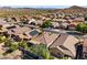 An aerial view of a desert community featuring a mix of homes with desert landscaping and solar panels on the roofs at 10749 W Lariat Ln, Peoria, AZ 85383
