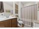 Well-lit bathroom featuring a shower with decorative curtain, wooden vanity, framed art, and stylish fixtures at 10749 W Lariat Ln, Peoria, AZ 85383