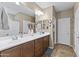 Bathroom features double sinks, wooden cabinets, and a large mirror, offering functionality and style at 10749 W Lariat Ln, Peoria, AZ 85383