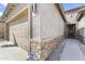 Close-up of the home's exterior showcasing stone accents, a tiled roof, and neutral stucco at 10749 W Lariat Ln, Peoria, AZ 85383