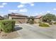 Beautiful home exterior featuring manicured shrubs, desert landscaping, and a spacious driveway at 10749 W Lariat Ln, Peoria, AZ 85383