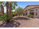 Beautiful backyard featuring desert landscaping, flowering bushes, and mature palm trees for serene outdoor living at 10936 N Ventana W Dr, Peoria, AZ 85373