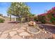 Serene backyard showcasing a rock water feature, vibrant bougainvillea bushes, and desert landscaping at 10936 N Ventana W Dr, Peoria, AZ 85373