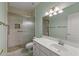 Bathroom showcasing a shower with glass doors, complemented by a sink with white cabinets and ample lighting at 10936 N Ventana W Dr, Peoria, AZ 85373