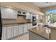 Eat-in kitchen featuring white cabinets, tile flooring, ample counter space, and stainless steel appliances at 10936 N Ventana W Dr, Peoria, AZ 85373