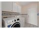 Laundry room with front load washer and dryer, cabinets, and a door to the exterior at 10936 N Ventana W Dr, Peoria, AZ 85373