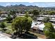 This is an aerial view of a community with mature landscaping, green spaces, and mountain views at 1120 E Beryl Ave, Phoenix, AZ 85020
