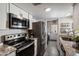 Galley kitchen featuring granite countertops, stainless steel appliances, and access to laundry area at 1120 E Beryl Ave, Phoenix, AZ 85020