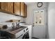 Functional laundry room with cabinetry, shelving, washer, dryer, and backyard access for easy chores at 1120 E Beryl Ave, Phoenix, AZ 85020