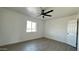 Bright bedroom with gray wood floors, ceiling fan and a window with natural light at 121 E Monte Way, Phoenix, AZ 85042