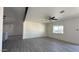 Spacious living room with gray wood-look floors, ceiling fan, and good natural light from the window at 121 E Monte Way, Phoenix, AZ 85042
