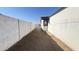 A long, narrow side yard features a block wall, dirt landscape, and access to the backyard at 121 E Monte Way, Phoenix, AZ 85042