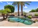 Private backyard with a freeform pool surrounded by mature landscaping and hardscape at 1410 S Los Altos Dr, Chandler, AZ 85286