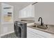 Laundry room boasts modern appliances, ample counter space, and stylish black and white patterned flooring at 1410 S Los Altos Dr, Chandler, AZ 85286