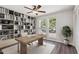 Bright home office featuring built-in bookshelves, a ceiling fan, two windows, and a light wood desk on a patterned rug at 1452 E Gary St, Mesa, AZ 85203