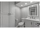 Updated bathroom features white cabinets, a modern toilet, stylish mirror, and wood-look flooring at 15235 S 30Th St, Phoenix, AZ 85048