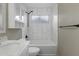 Bright bathroom featuring white marble-style tile, a tub and shower, and modern fixtures at 15235 S 30Th St, Phoenix, AZ 85048