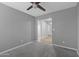 Bedroom features a ceiling fan, neutral gray paint, plush carpet, and an adjacent bathroom for convenience at 15235 S 30Th St, Phoenix, AZ 85048