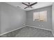 Comfortable bedroom boasts a ceiling fan, neutral gray paint, new carpeting, and natural light from the window at 15235 S 30Th St, Phoenix, AZ 85048