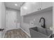 Modern laundry room features gray walls, wood-look floors, and white cabinets with a deep utility sink at 15235 S 30Th St, Phoenix, AZ 85048