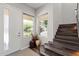 Bright foyer featuring a modern front door, windows, hardwood staircase, and neutral decor at 1555 E Ocotillo Rd # 16, Phoenix, AZ 85014