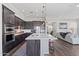 Modern kitchen featuring a large island, stainless steel appliances, and dark cabinetry, open to the living area at 1555 E Ocotillo Rd # 16, Phoenix, AZ 85014
