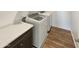 Convenient laundry room with wood-look floors, modern washer and dryer, and a folding counter at 16236 W La Ventilla Way, Goodyear, AZ 85338