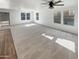 Spacious living room with a ceiling fan, sliding glass doors, and large windows at 16236 W La Ventilla Way, Goodyear, AZ 85338