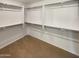 A walk-in closet is shown featuring white walls, carpet, and metal hanging rods at 16236 W La Ventilla Way, Goodyear, AZ 85338