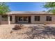 Rear view of home exterior and backyard, featuring gravel and a fire pit at 1642 E Desert Ln, Phoenix, AZ 85042