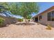 Backyard featuring gravel, trees, exterior of home, and privacy wall at 1642 E Desert Ln, Phoenix, AZ 85042