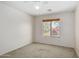 Bedroom with neutral walls, ceiling fan, plush carpet, and a bright, sunny window at 1642 E Desert Ln, Phoenix, AZ 85042