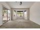 Spacious carpeted bedroom featuring a ceiling fan, bay windows, and sliding glass door to the backyard at 1642 E Desert Ln, Phoenix, AZ 85042