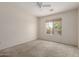 Bright bedroom featuring neutral carpet, ceiling fan, and window with exterior views at 1642 E Desert Ln, Phoenix, AZ 85042