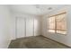 Standard bedroom with a sliding door closet, plush carpet, and sunny, bright window at 1642 E Desert Ln, Phoenix, AZ 85042