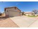 Side view of home featuring a two car garage, desert rock landscaping, and a concrete driveway at 1642 E Desert Ln, Phoenix, AZ 85042