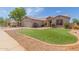 Single story home boasting low maintenance landscaping, desert rock, and a pop of green grass at 1642 E Desert Ln, Phoenix, AZ 85042