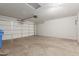 Spacious two-car garage with white door and overhead lighting at 1642 E Desert Ln, Phoenix, AZ 85042