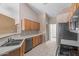 Galley style kitchen with laminate counters, tiled floors, wooden cabinets, and steel appliances at 1642 E Desert Ln, Phoenix, AZ 85042