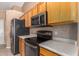 Kitchen boasts stainless steel appliances, wood cabinetry, and ample counter space at 1642 E Desert Ln, Phoenix, AZ 85042