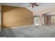 Carpeted living space featuring two-toned walls, arched entryways, and natural light from the window at 1642 E Desert Ln, Phoenix, AZ 85042